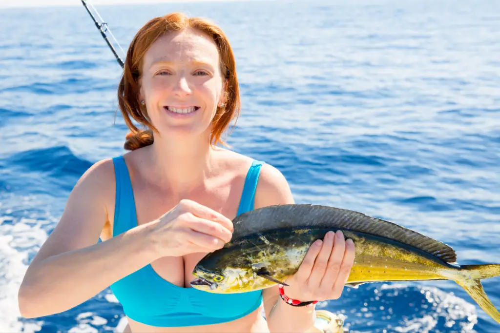 female angler holds fresh caught mahi mahi 