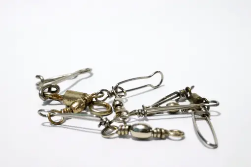 various types of fishing swivels on a white background