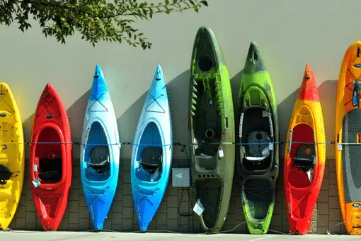 eight kayaks leaning against a wall