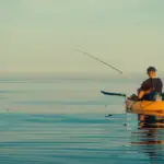 angler fishing from a kayak on crystal blue water