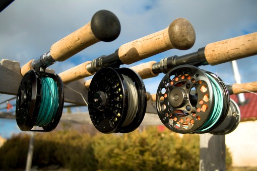 four fly fishing rods on a timber rod holder
