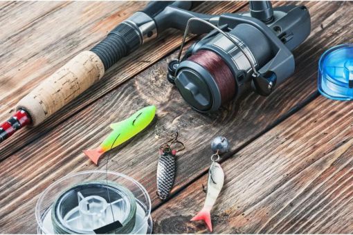 rod, reel, fishing line and lures on wooden deck