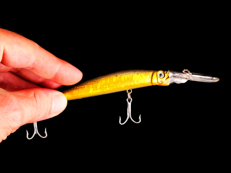 a brown lure being held against black background