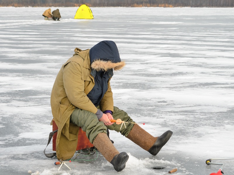 a man ice fishing eagerly awaiting a bite