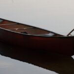 anchored canoe on a still lake