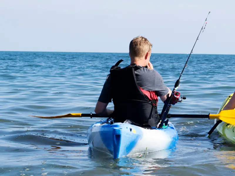 kayak angler with small spinning rod on the back