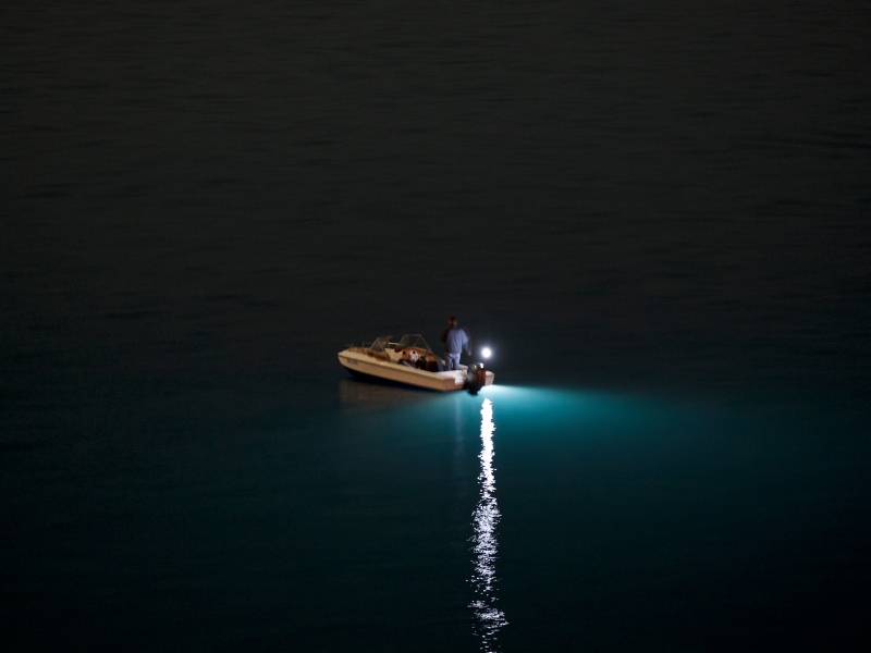 small boat fishing at night