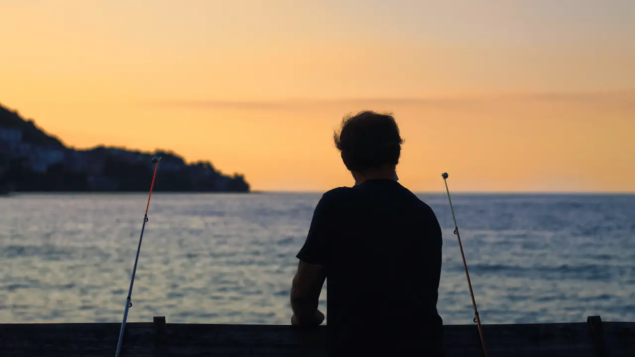 man enjoying a evening fish from a pier